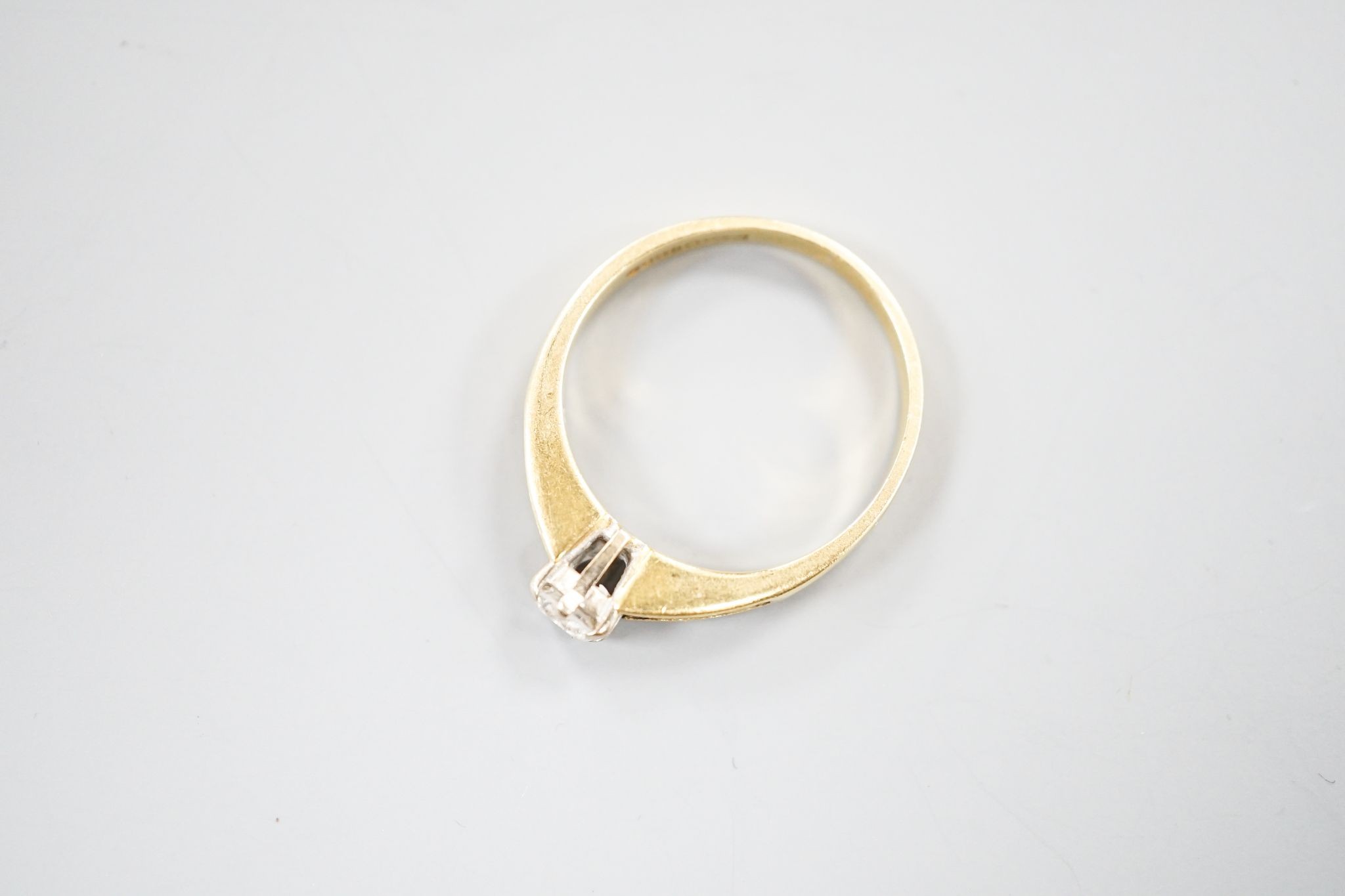 A modern 18ct gold and single stone diamond ring, with diamond set shoulders, size L, gross 2.4 grams.